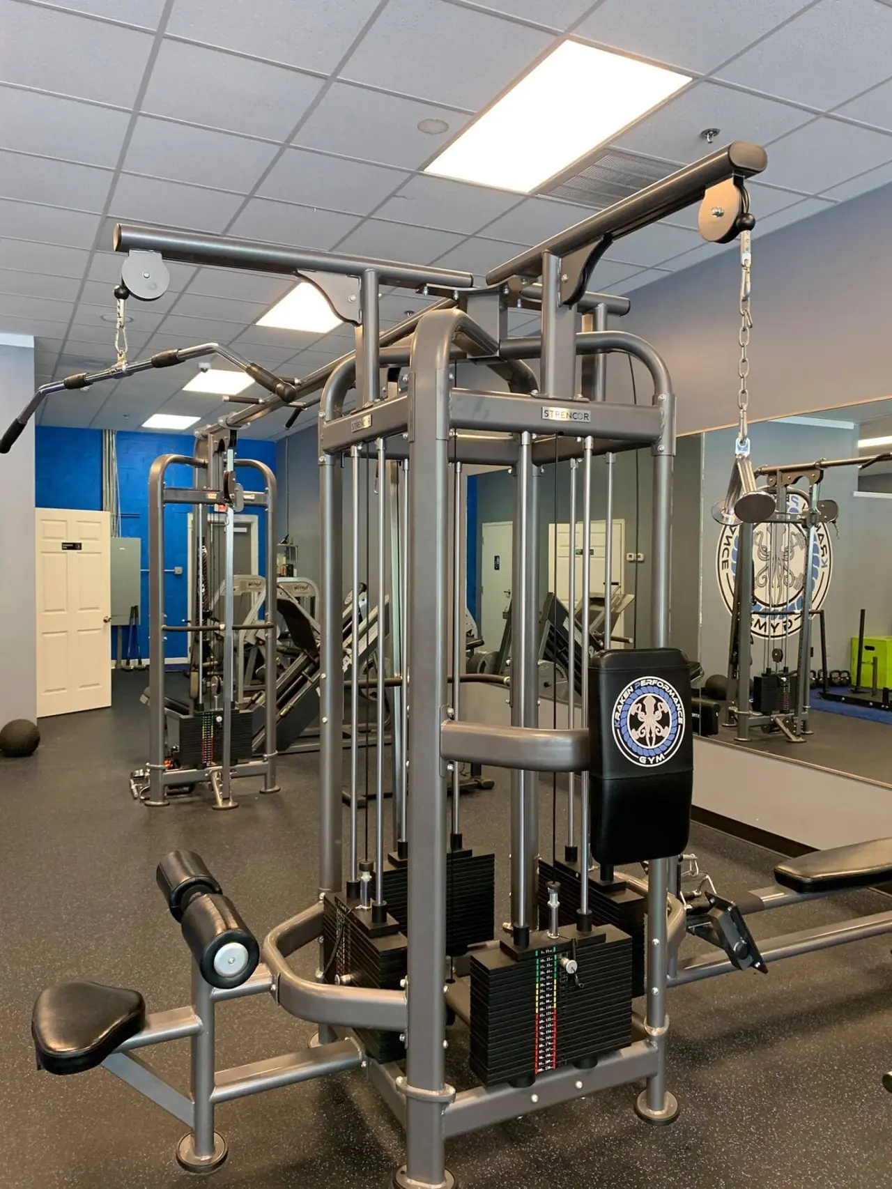Strencor four-stack cable jungle gym with a Kraken-branded pad and crossover arms overhead.