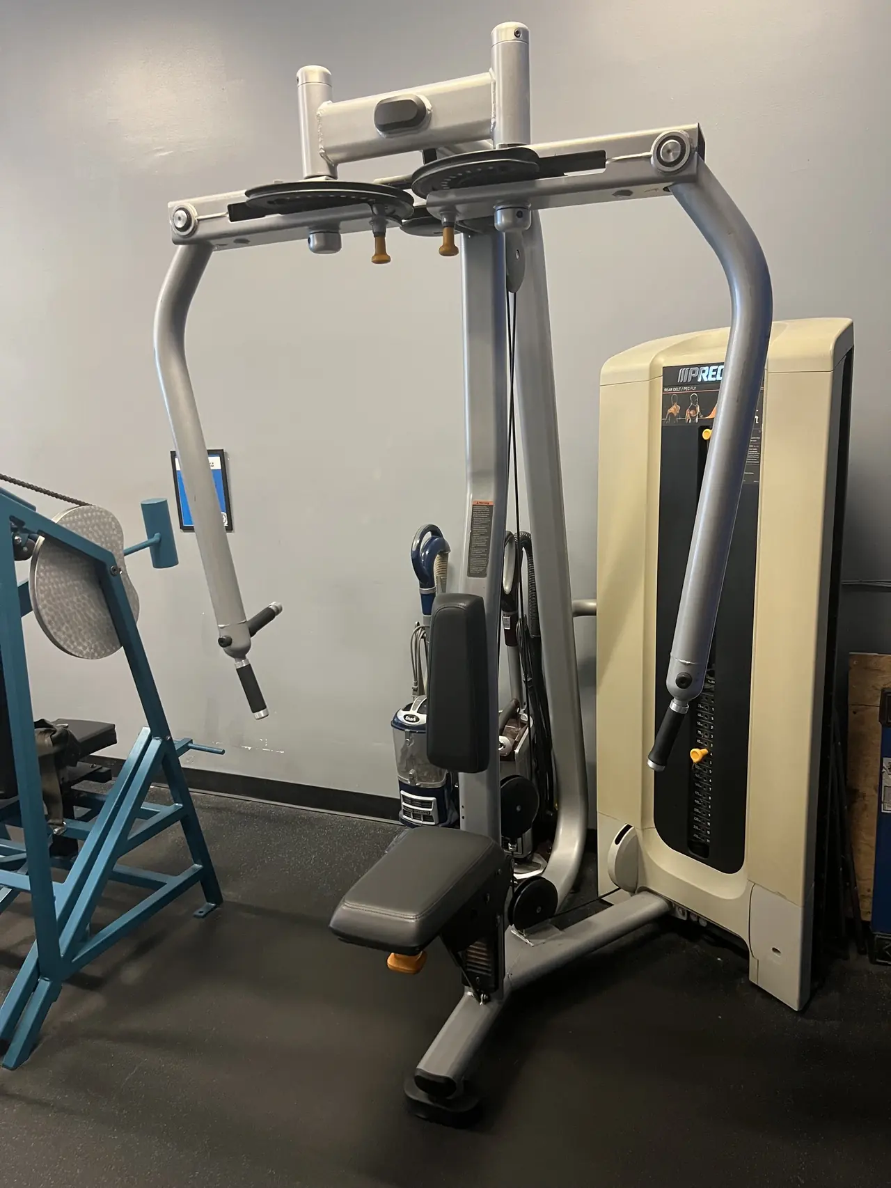Precor pec deck and rear-delt fly station, next to the teal Nautilus pullover.